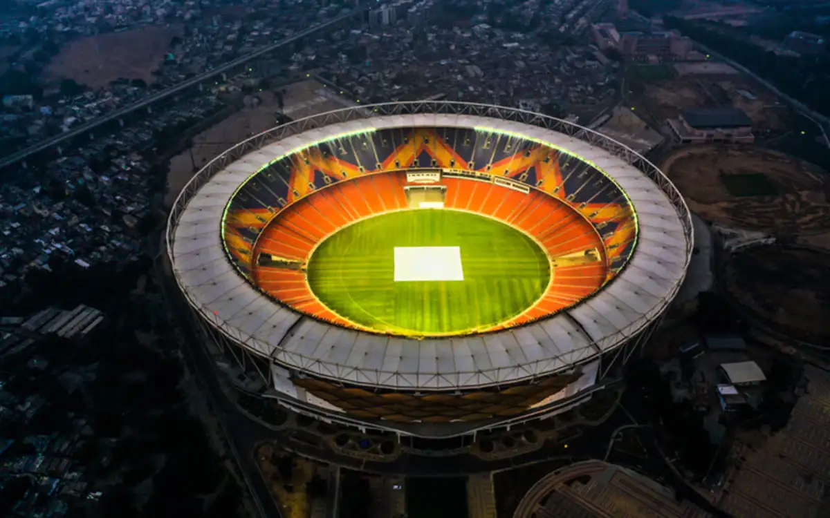 Aerial view of Narendra Modi Stadium, the world's largest cricket stadium, illuminated at night.